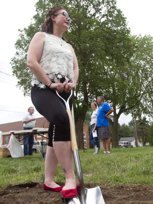 Rebecca Gremore digs the first shovelful of dirt Thursday, July 13, 2017 at the groundbreaking for the Habitat for Humanity house that will be home to her and her children.