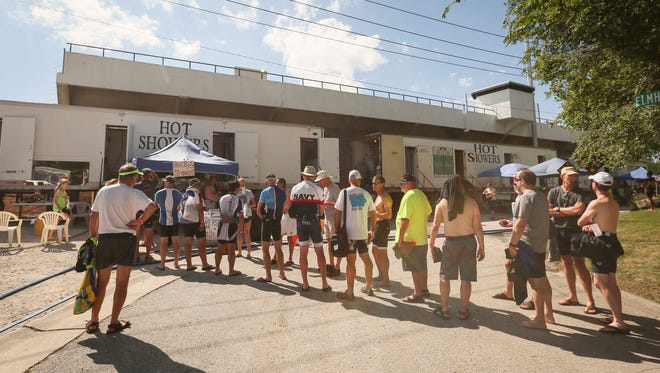 Riders wait for showers provided by the Pork Belly charter in Fort Dodge during RAGBRAI in 2015.