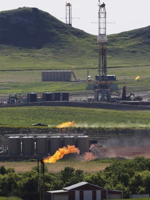 
In this June 2014 file photo, natural gas is flared at an oil production facility in Watford City, N.D. North Dakota has the lowest unemployment in the 50 states. 
