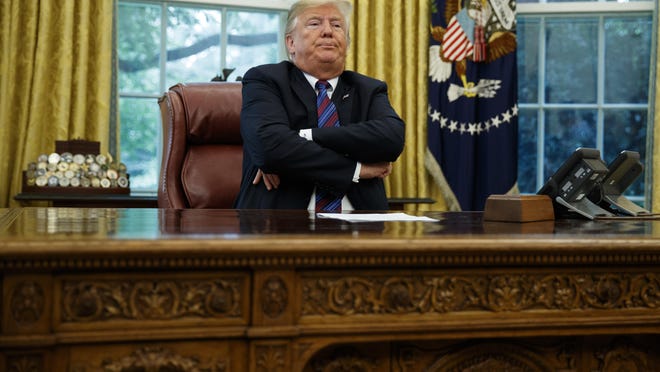 President Donald Trump crosses his arms after speaking with Mexican President Enrique Pena Nieto on the phone about a trade agreement between the United States and Mexico, in the Oval Office of the White House, Monday, Aug. 27, 2018, in Washington. Trump has bowed to widespread pressure from veterans groups and others to do more to honor John McCain's death. Trump on Monday ordered flags at the White House and elsewhere lowered to half-staff until the six-term senator is buried Sunday. He also proclaimed "respect" for McCain, with whom he feuded bitterly for years. It was a marked reversal from Trump's refusal to comment on McCain. Earlier Monday, the White House flag had been raised. (AP Photo/Evan Vucci)