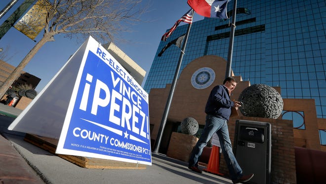 Pedestrians walk past campaign signs outside the polling station at the El Paso County Courthouse. Early voting runs through Feb. 26 for several primary races, including the presidential primary.