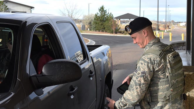 Airman 1st Class Dylan Kerns, 341st Security Forces Squadron member, checks identification cards for incoming visitors through the 10th Avenue North Access Gate at Malmstrom Air Force Base, Mont.