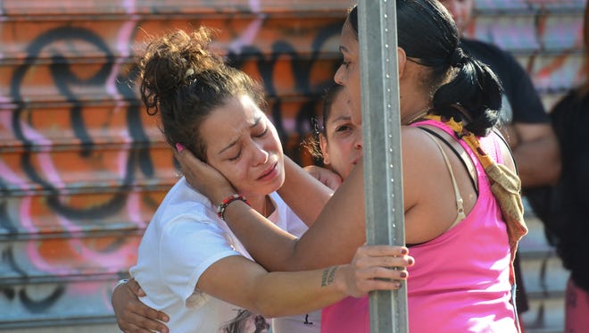 At left, a woman identified as Naomi Lopez Miranda, the wife and also the mother of one of the victim's children, crying at the scene. Passaic County Sheriff Department and Prosecutors Office investigate the fatal shooting of a man by Paterson Police on Summer Street in the early morning hours on a Friday in June.