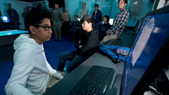 Pine Forest High School students Angelo Mayorga, left, and Alec Le, right, and nearly two-dozen other students from Escambia and Santa Rosa County schools prepare for CyberTron 2015 at the National Flight Academy Friday morning Jan. 23, 2015. The weekend long event is designed to help educate and test the cyber security skills of the participating students.