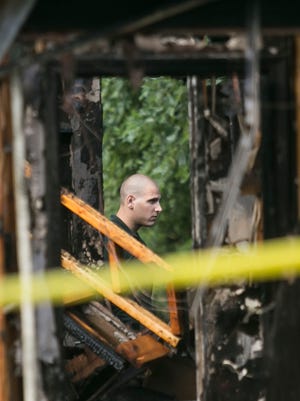 A man looks through charred debris as firefighters inspect the damage at 739 Sunset Road on Tuesday, Aug. 2, 2016, in Hellam Township. The cause of the fire is under investigation. Amanda J. Cain photo