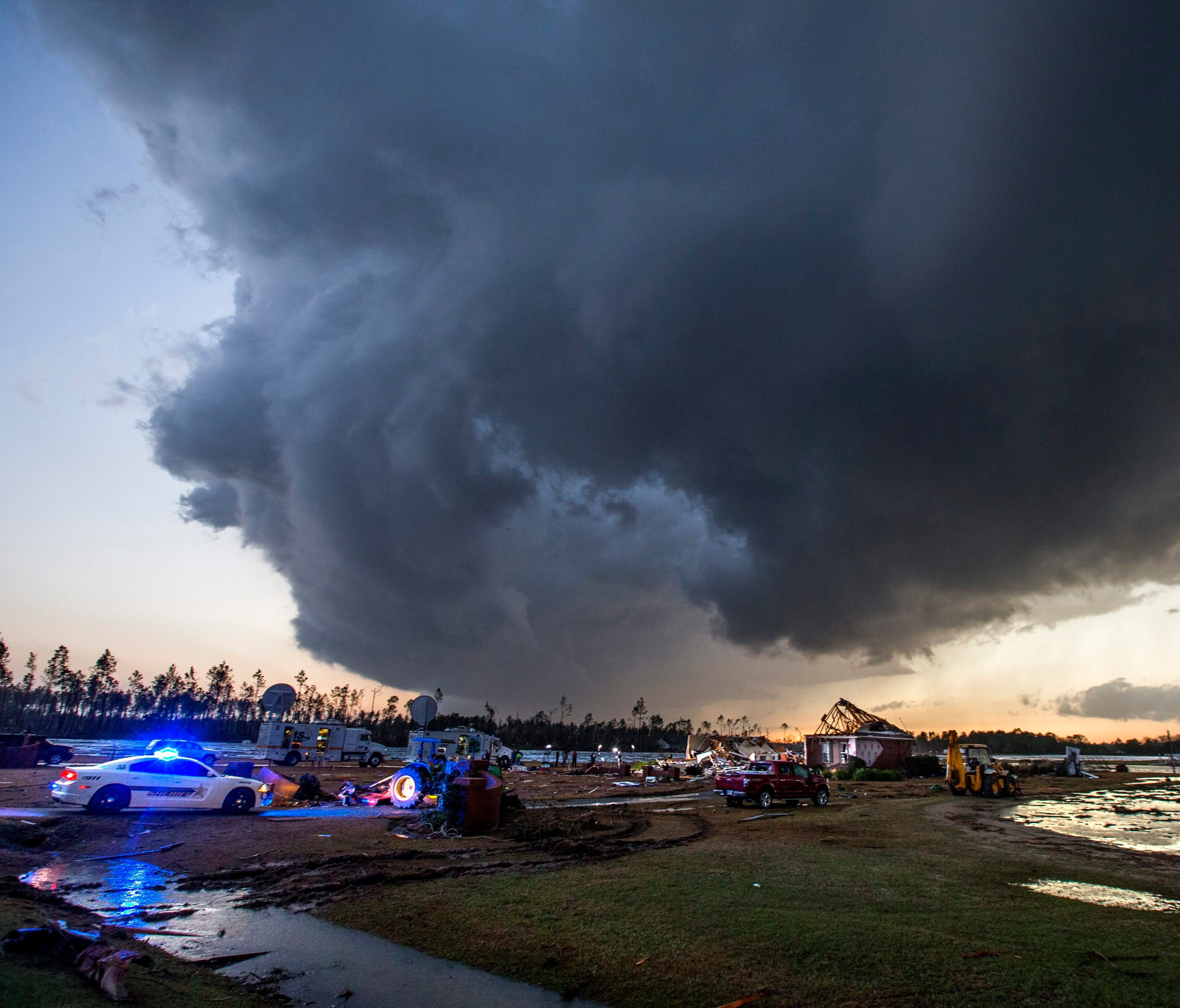 Storm clouds approach emergency crews at the scene of a house that was cut in half by a tornado outside Adel, GA. Jan 22, 2017.  Emergency officials report that at least eleven people were killed during the severe weather outbreak in the south.