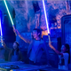 Young kids hold up custom lightsabers at Star Wars: Galaxy's Edge workshop at Disney's Hollywood Studios.
