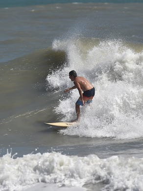 Surfers ride the waves at Fort Pierce Inlet State Park as swells from Hurricane Maria kick up the surf on Monday, Sept. 25, in Fort Pierce. 