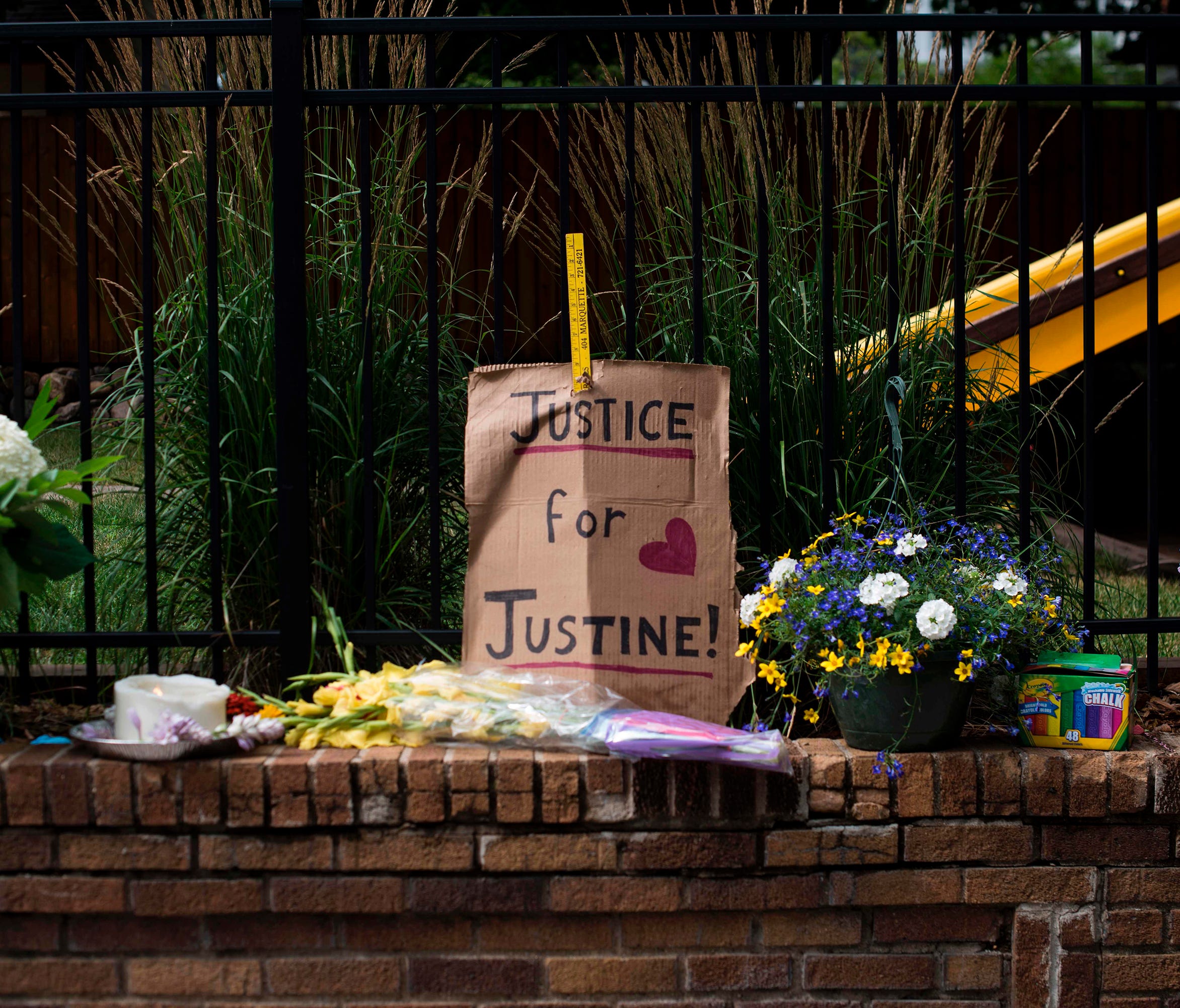 A sign and flowers are left at a makeshift memorial for Justine Damond on July 18, 2017, in Minneapolis.