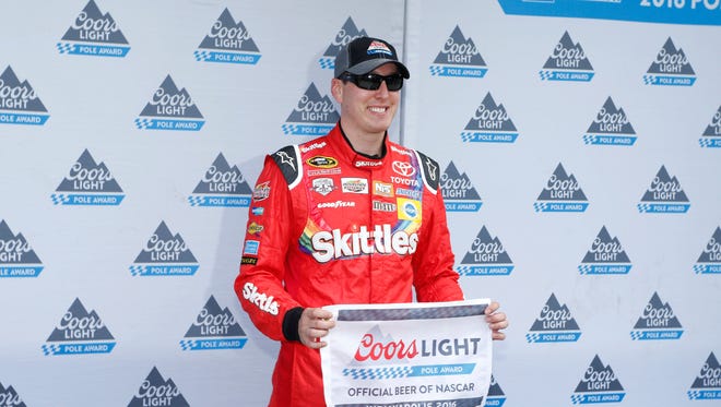 Kyle Busch poses for the pole award Saturday after being the faster qualifier for the Combat Wounded Coalition 400 at the Brickyard at Indianapolis Motor Speedway.