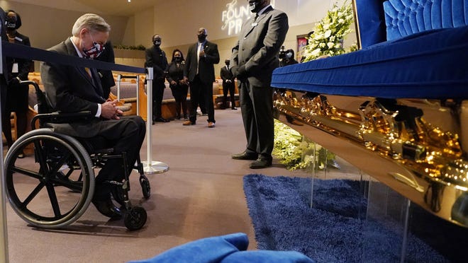 Texas Gov. Greg Abbott passes by the casket of George Floyd on Monday during a public visitation at Fountain of Praise Church in Houston.