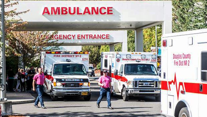 Paramedics return to their ambulances after delivering patients to Mercy Medical Center in Roseburg, Ore., following a deadly shooting at Umpqua Community College, on Oct. 1, 2015.