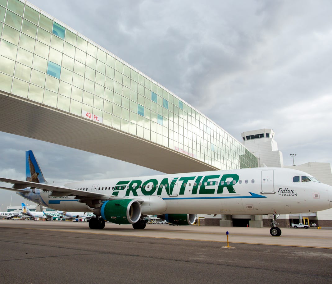 A Frontier Airbus A321 passes under the pedestrian bridge at  Denver International Airport on May 7, 2017.