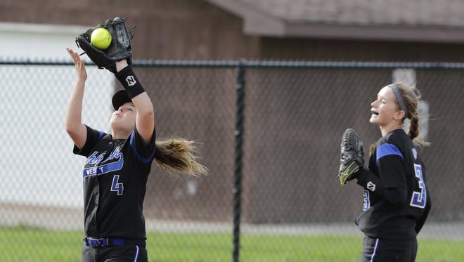 Oshkosh West's Emily Miller makes a catch near third base as Hailey Hendrix assists on Thursday. Miller finished with seven assists and five putouts in the game.