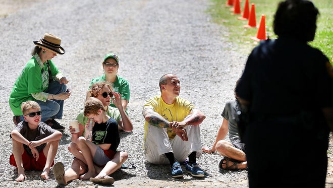 May 30, 2016 - Maureen Spain and her two sons Calvin Whitt (left) and Gus Whitt (front row) sit with fellow demonstrator Ceylon Mooney during an act of civil disobedience blocking the Greensward parking area at Overton Park. A crowd of protesters gathered in opposition to the continued use of the Greensward by the Memphis Zoo parking where two people were eventually arrested. (Jim Weber/The Commercial Appeal)