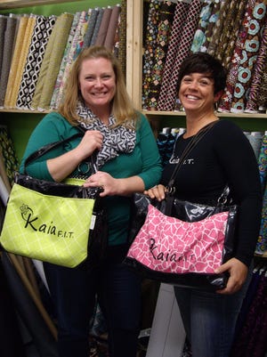 Karen Scott of Too Cute Totes, left, and Andrea Schell of Kaia FIT pose with Kaia Queen athletic bags crafted by Scott. The two business owners have partnered up to offer free Kaia FIT sessions for one Fallon and one Fernley woman.