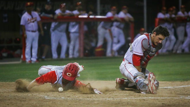 Corona's Chase Robison slides and scores.