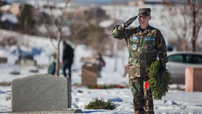 Civil Air Patrol Cadet Chris Lennon salutes a grave after laying down a wreath during the annual Wreaths Across America event at the Tonaquint Cemetery.