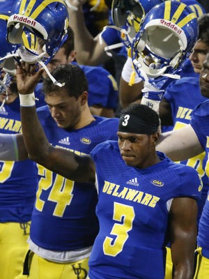Delaware quarterback Joe Walker joins his team as they gather for the alma mater after the conclusion of Delaware's 28-21 loss to Maine at Delaware Stadium Saturday.
