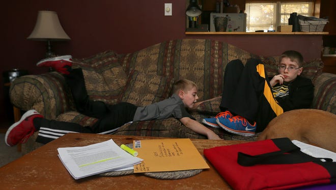 Landon Jones, 12, sits with his brother, Bryce, 9, left. Landon is losing weight, apparently because of a hypothalamic dysfunction, and has to be reminded to eat and drink.