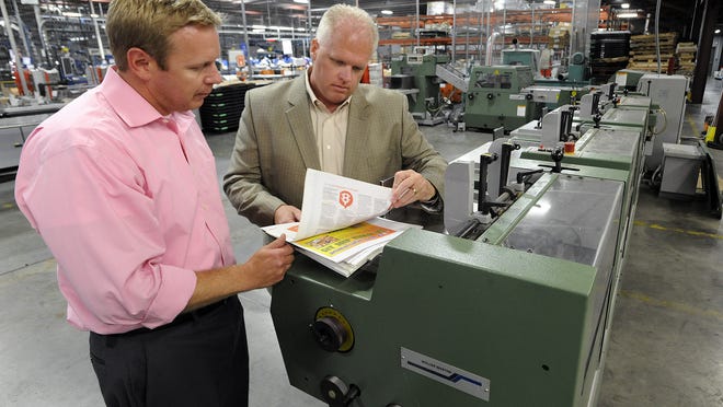 
“Montgomery Advertiser” production manager Roger Holmes, left, and “Montgomery Advertiser” publisher Robert Granfeldt Jr. look at the Mueller Martini Bravo bindery machine at the newspaper’s production facility on Tuesday.

