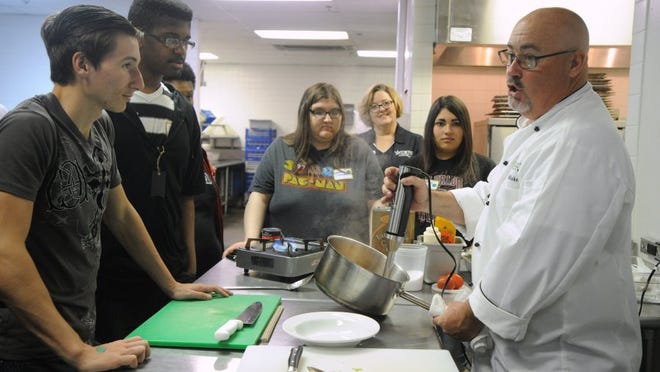 Nellie Doneva/Reporter-News   TSTC chef Blake Liles, right, shows students how to make a tomato basil soup during the Food Truck Frenzy program, sponsored by TSTC.