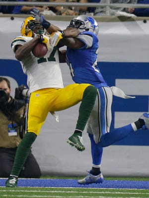 The Packers' Davante Adams grabs a touchdown pass in the fourth quarter with tight coverage from the Lions' Nevin Lawson.