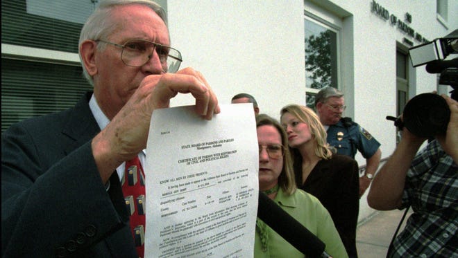 Former Alabama Gov. Guy Hunt displays his pardon from Alabama State Board of Pardons and Paroles on Tuesday, March 31, 1998, in Montgomery. The pardon was granted one day after Hunt paid restitution of $208,500. He ran for governor again that year and failed to make the Republican primary run-off. Hunt died in 2009.