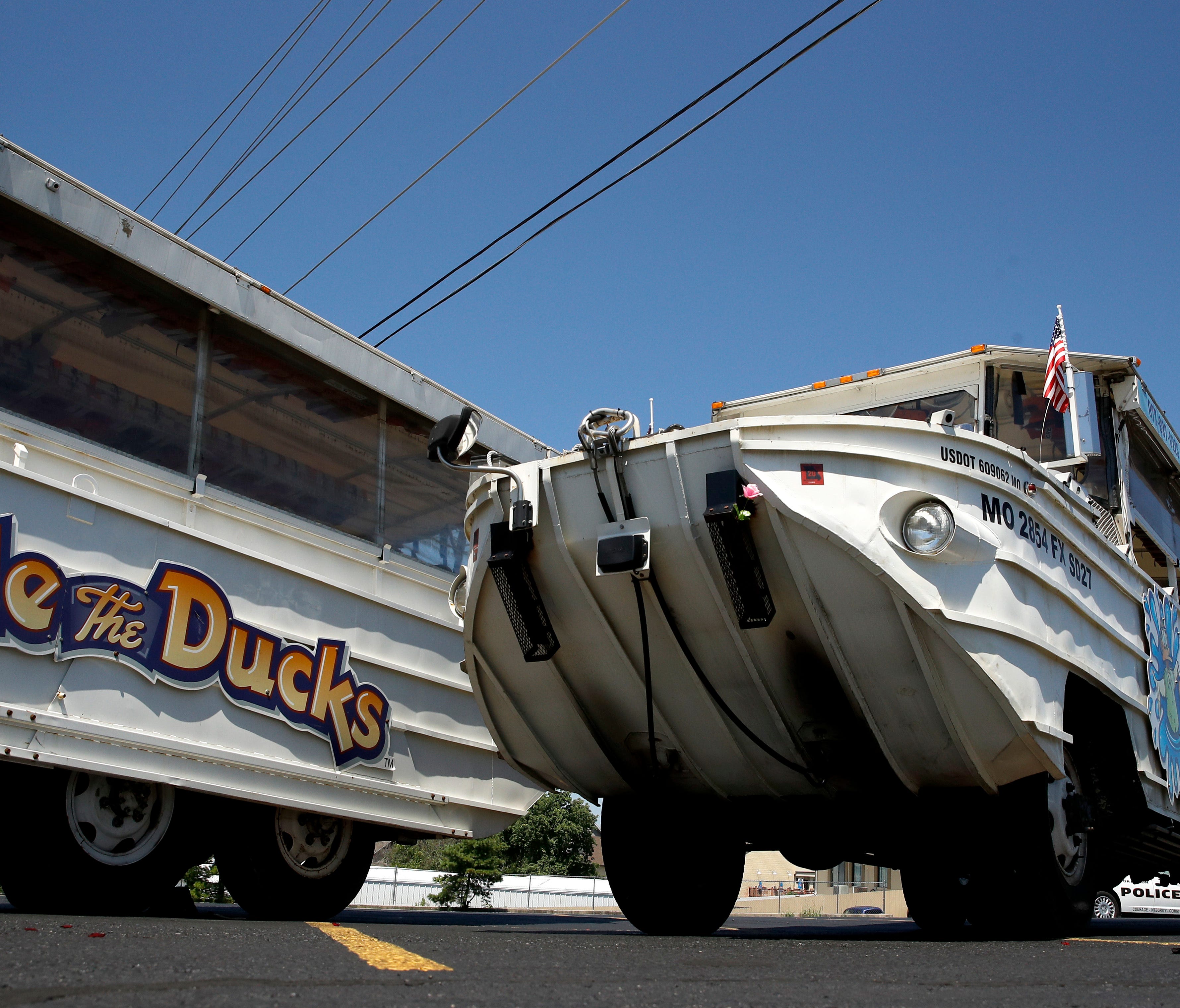 A man looks at an idled duck boat in the parking lot of Ride the Ducks in Branson, Mo.