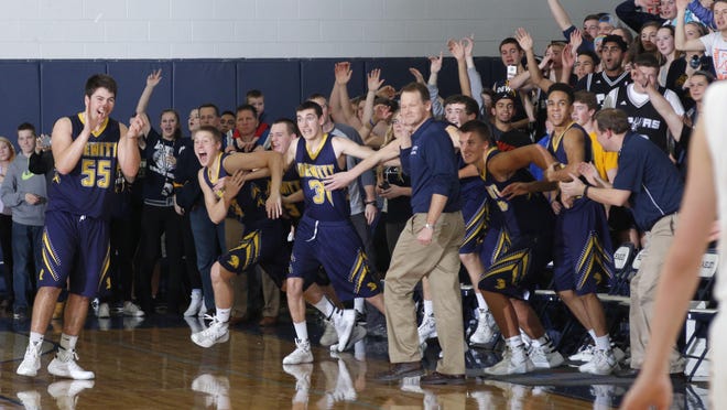 DeWitt players, the bench and fans celebrate as time expires in a 77-72 overtime win over Haslett Friday, Jan. 15, 2016, in Haslett, Mich.