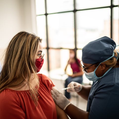 A healthcare worker gives an injection to a patien
