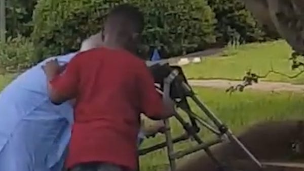 Boy jumps out of SUV to help woman struggling...