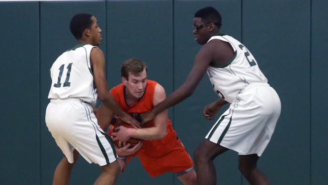 Middletown North's Colin Frawley (center) battles to keep the ball from East Brunswick's Mike Vick (left) and Dante Ralph during their NJSIAA Central Group IV first round game on Tuesday.