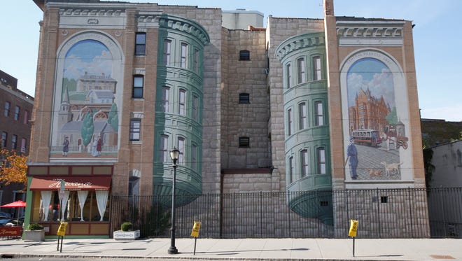 Muralist Richard Haas painted three iconic murals in 1997 on the walls of three buildings near the intersection of Main Street and Riverdale Avenue.