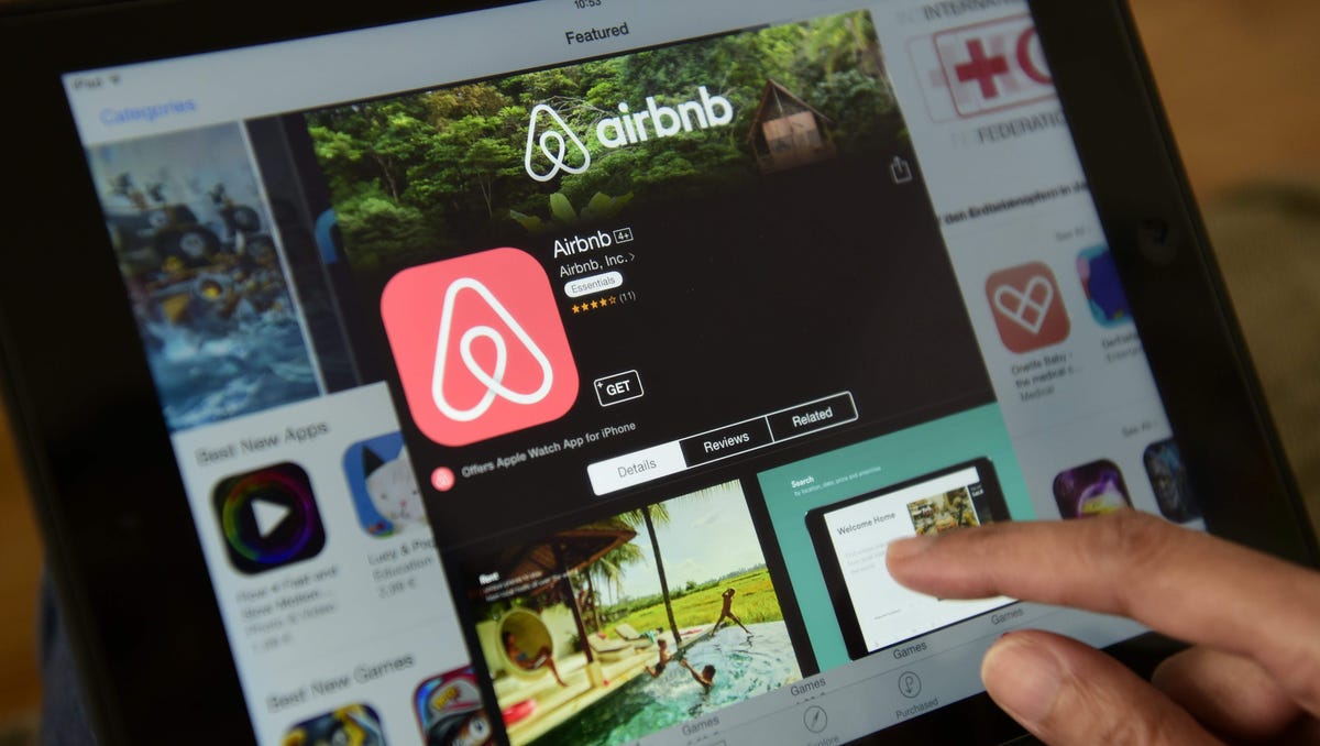 A woman browses the site of U.S. home sharing giant Airbnb on a tablet in Berlin on April 28, 2016.