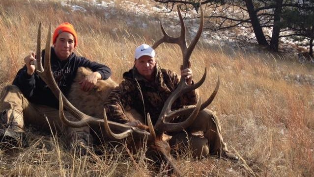 Luke Almos, left, got this bull elk while hunting with his brother Andrew and his father Travis.