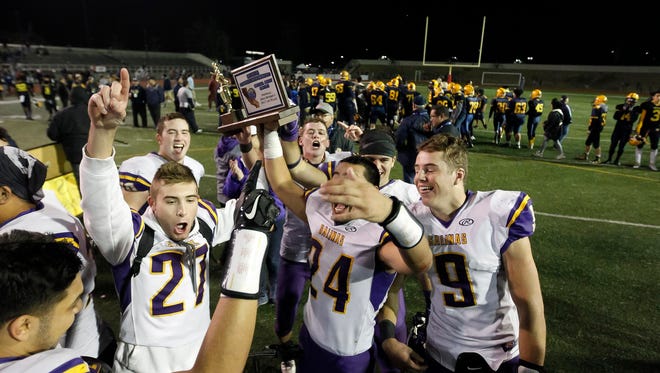 Salinas hoist the championship trophy as they celebrate defeating Milpitas during a Central Coast Section: Open Division I Championship football game between the Salinas Cowboys and the Milpitas Trojans at Independence High School on Friday, December 1, 2017 in San Jose, Calif. Vernon McKnight/for The Californian