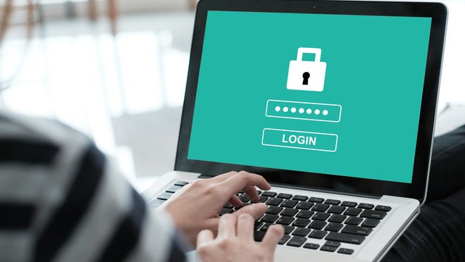 A person entering a password on a laptop