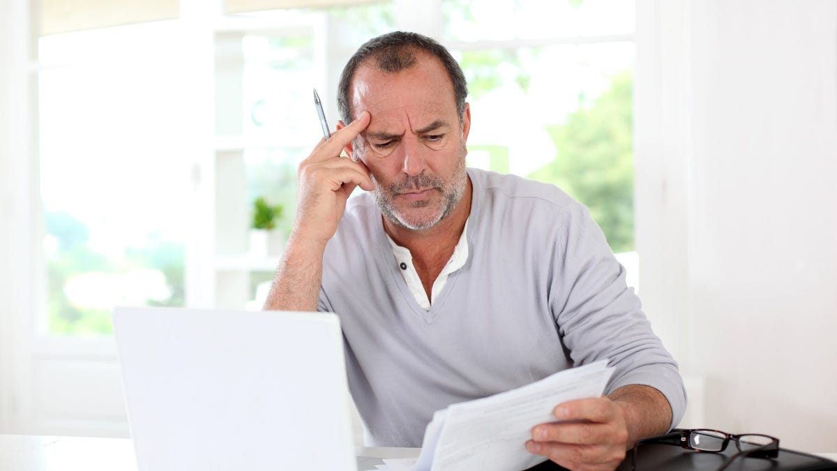 Mature man frowning and looking at documents
