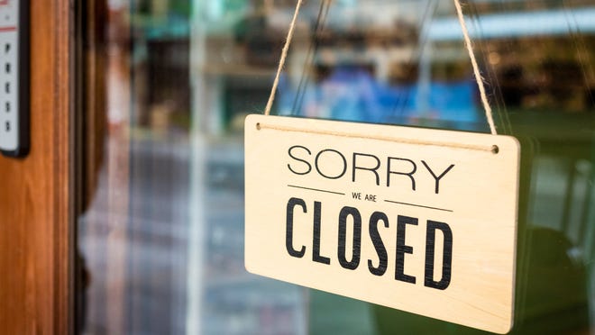 A "sorry we are closed" sign hangs on a door.