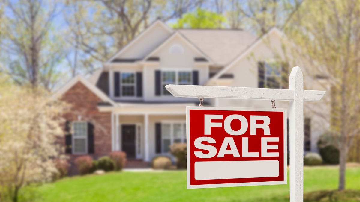 A "For Sale" sign in front of a home.