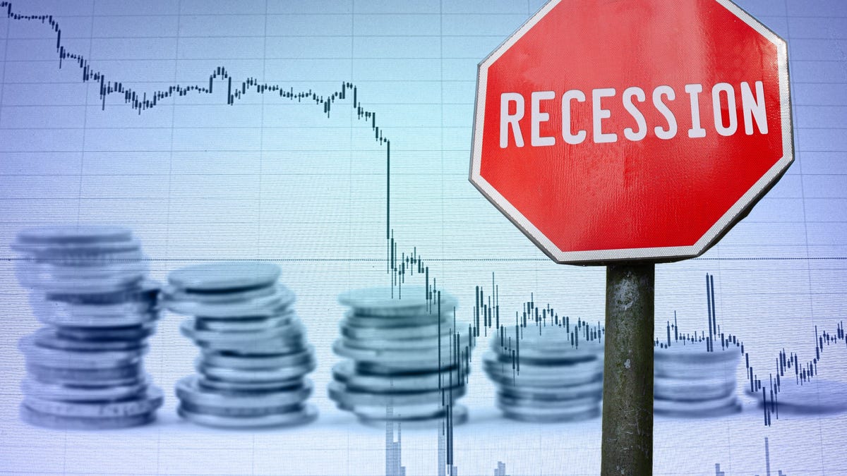 Red "recession" sign in front of a chart with a declining line.