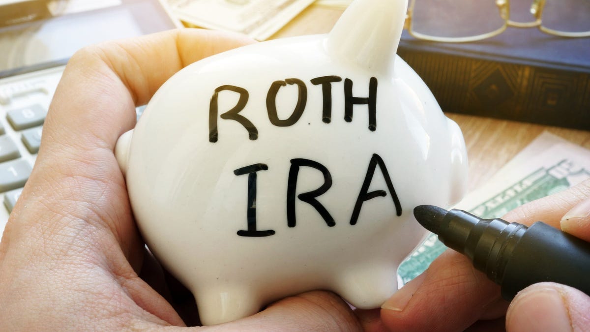 Hand holding piggy bank with Roth IRA written on it