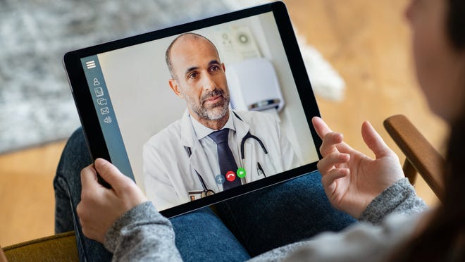 A patient conducting a telemedicine visit with a physician using a tablet.