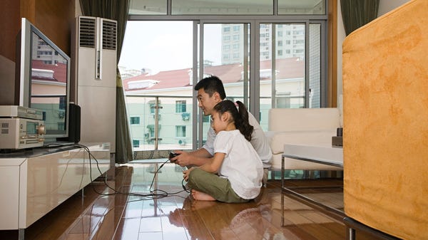 A father and daughter sitting on the floor playing