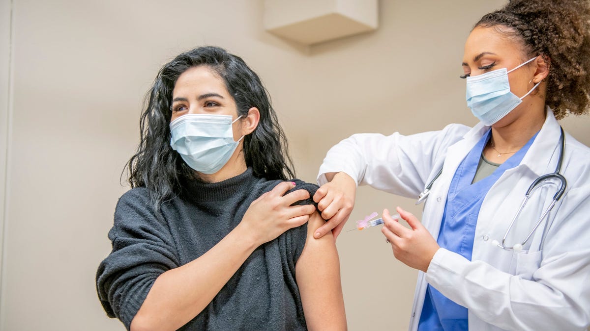 A healthcare professional giving a shot to a person.