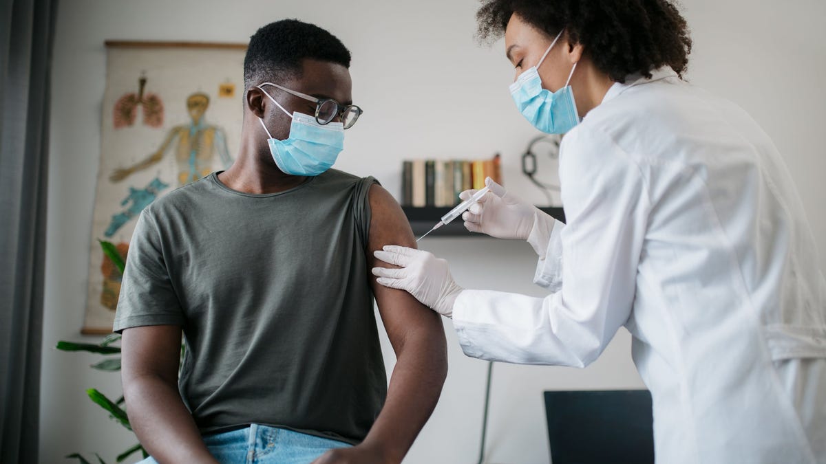 A healthcare professional giving a shot to a patient.