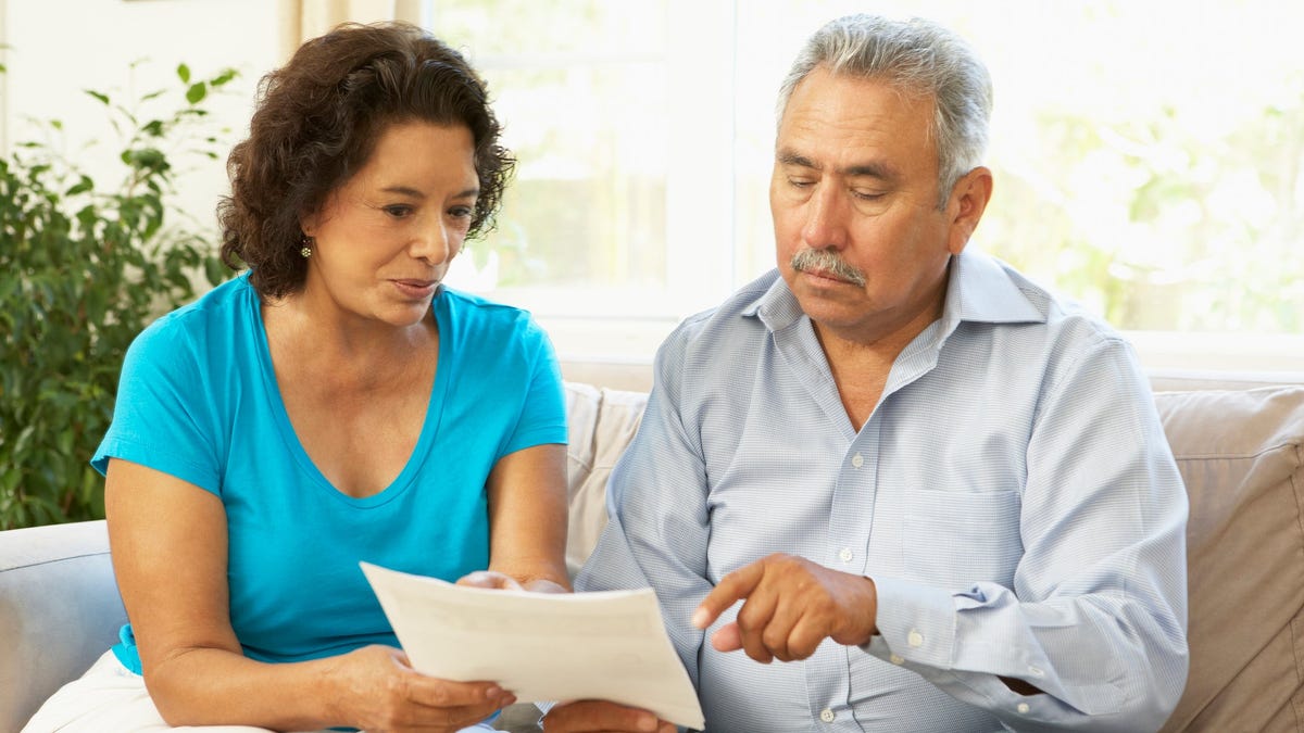 Senior couple pointing at document