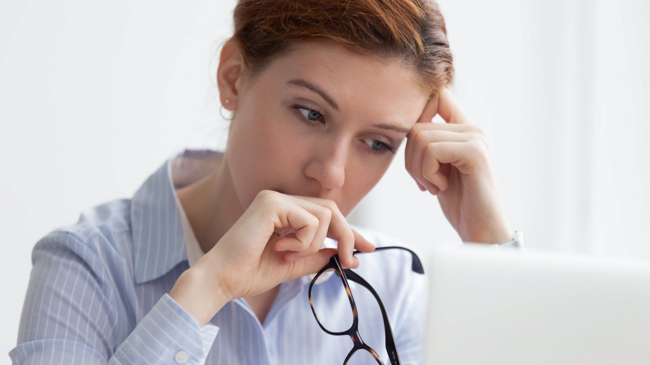 Person looking at their computer worried.