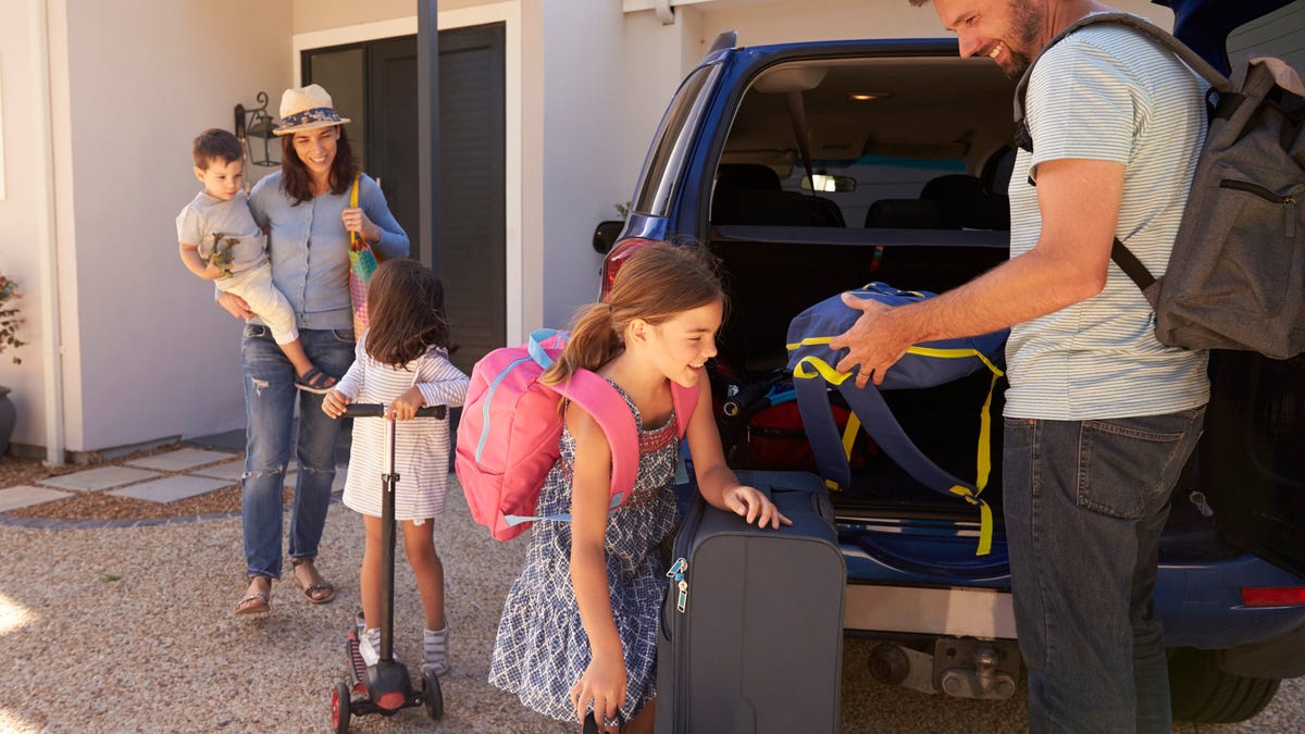 A family unloading luggage from a car.